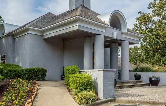 the front of a building with columns and a walkway