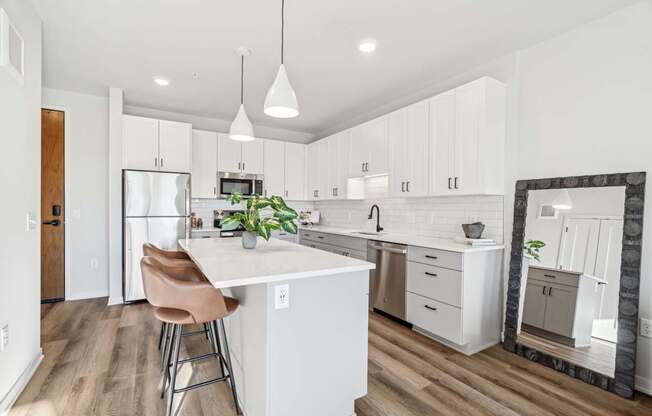 A kitchen with a white island and a refrigerator.