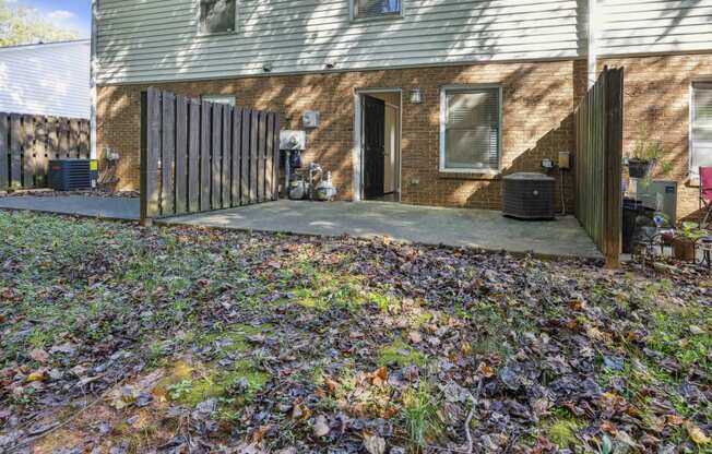 the back of a house with a patio and a fence