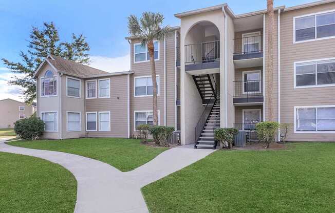 Apartment complex with a walkway in front.