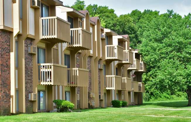 a row of apartment buildings with balconies and trees in the background at Beacon Hill and Great Oaks Apartments, Rockford, IL