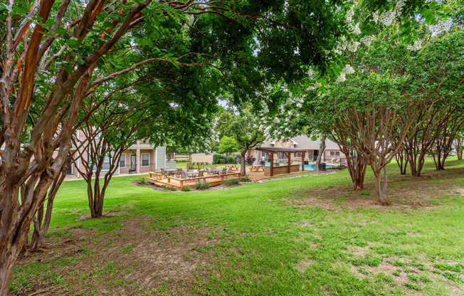 a yard with trees and houses in the background