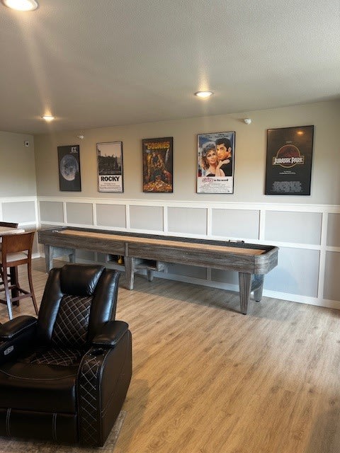 a living room with a pool table and a chair