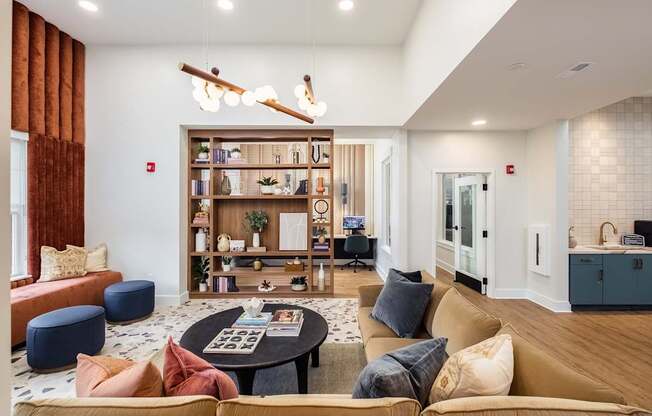 a living room with couches and a coffee table in front of a book shelf