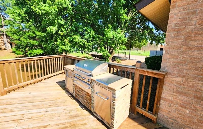 A wooden deck with a grill and a cooler on it.