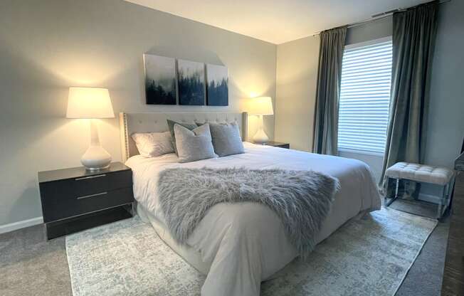 a bedroom with a large bed and a window at Evergreen Luxury Apartments, Merrillville
