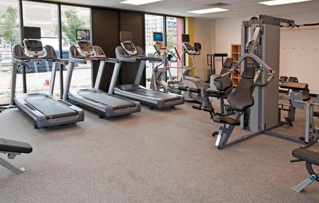 A gym with treadmills, elliptical machines, and weight machines.