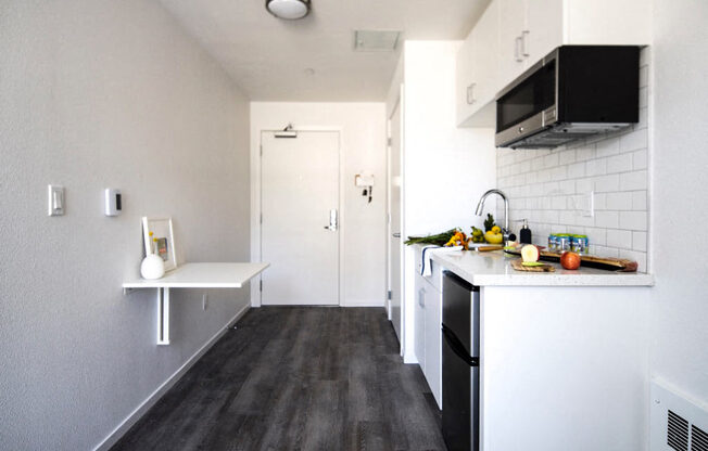 a small kitchen with white cabinets and black appliances