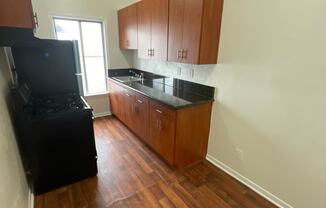 Kitchen with hardwood floors and cabinets at Sanborn/Hoover Apartments in Los Angeles, CA.