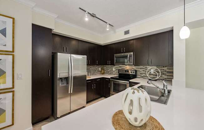a kitchen with stainless steel appliances and a white counter top
