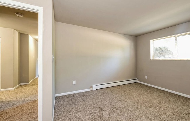 an empty room with carpet and a window