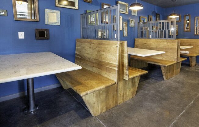 A blue room with wooden benches and tables.