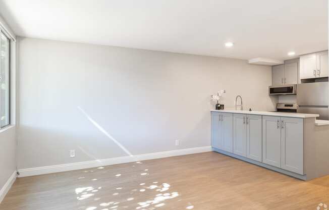 an empty kitchen with blue cabinets and a wood floor