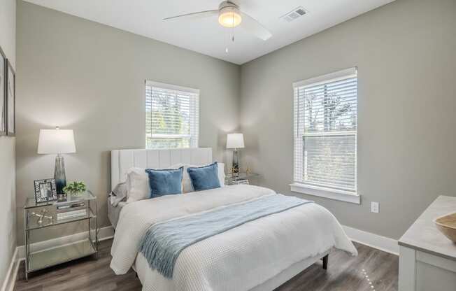 a bedroom with a bed and two windows