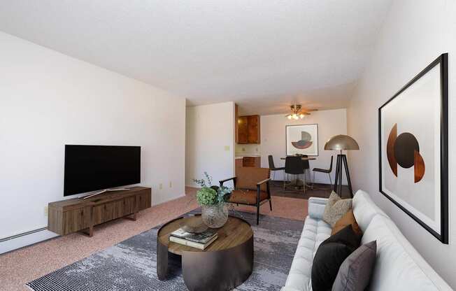 a living room with a white couch and a television. Fargo, ND Betty Ann Apartments