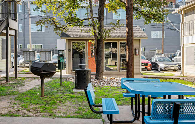 a picnic area with tables and chairs in front of a building