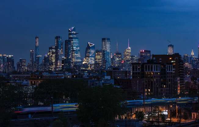 a view of the city skyline at night at One Ten Apartments, New Jersey, 07310