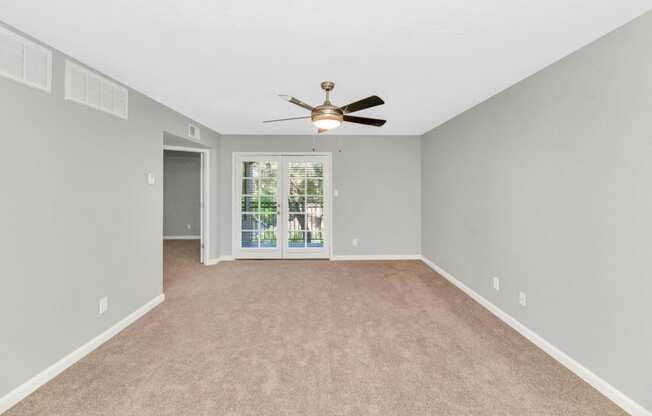 a large empty room with a ceiling fan