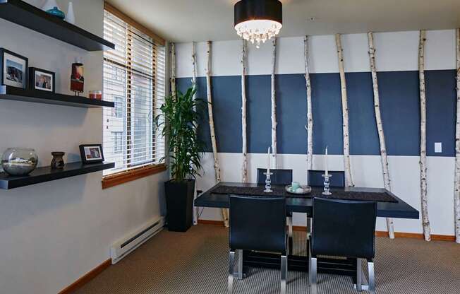 A dining room with a black table and chairs.