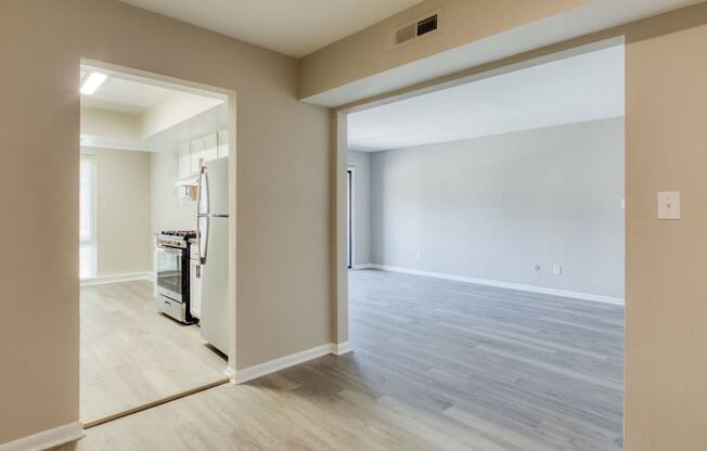 an empty living room and kitchen with a door open to the dining room at Bayville Apartments, Virginia Beach, 23455