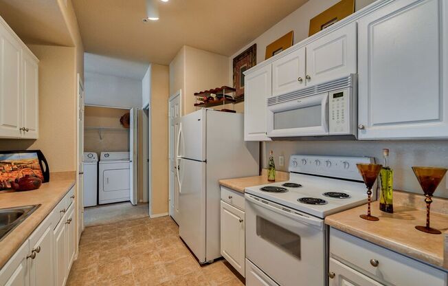 a kitchen with white appliances and white cabinets at Club at Coldwater Springs, Avondale, AZ