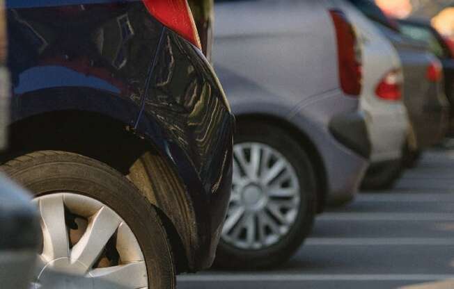 A line of cars parked in a parking lot with the words "FREE PARKING" superimposed on the image.