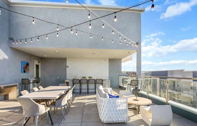 A patio with white furniture and string lights.