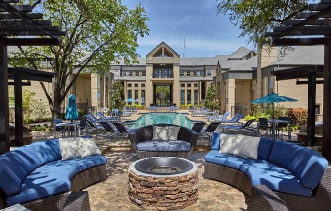 a patio with couches and a fire pit in front of a building