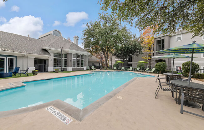 Community Swimming Pool with Pool Furniture at Bridges at Oakbend Apartments in Lewisville, TX.