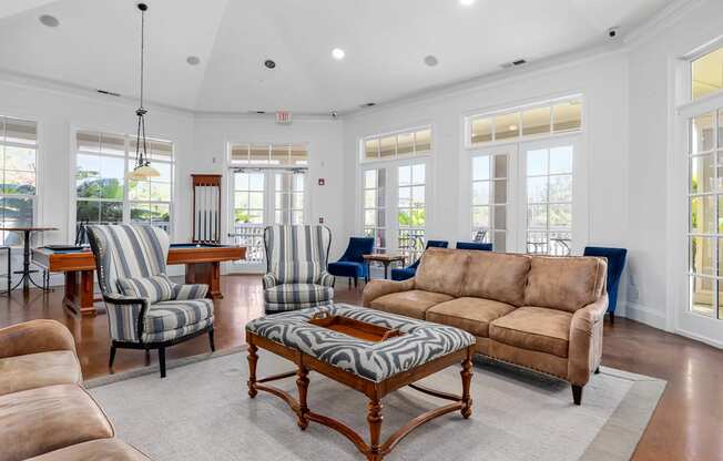 A living room with a brown sofa and striped chairs.