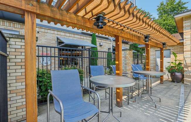 a patio with tables and chairs and a pergola