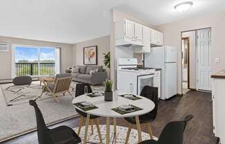 A modern kitchen with white appliances and a dining table set for two.