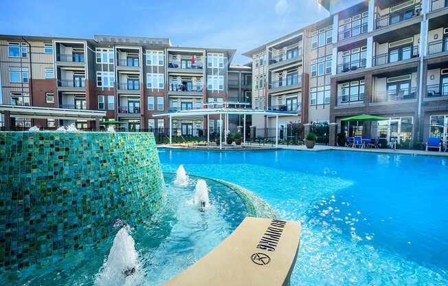 Rowlett Apartments for Rent - Harmony Luxury Apartments Exterior Pool with Spa and In-Water Lounge Chairs