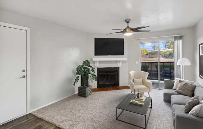 Model Living Room with Wood-Style Flooring, Fireplace and Patio Accessibility at Tanque Verde Apartments located in Tucson, AZ.