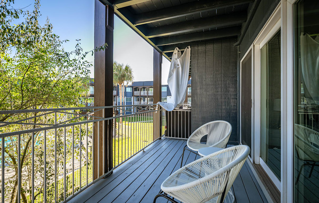 a balcony with two chairs and an umbrella on it