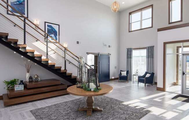 A living room with a staircase and a dining table.