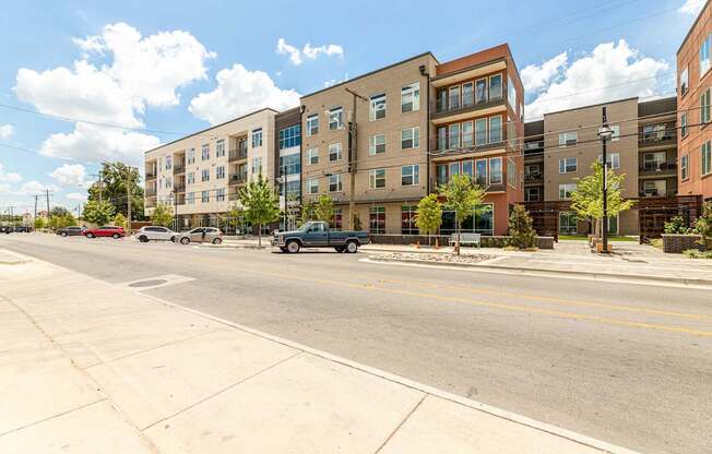 A street view of a residential area with cars parked on the side of the road.