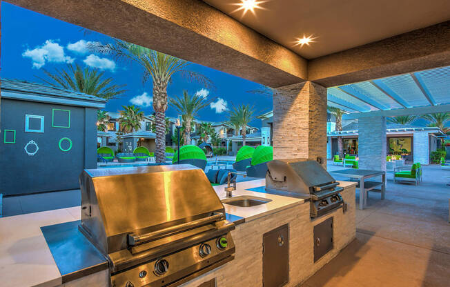 A modern outdoor kitchen with a grill and sink.