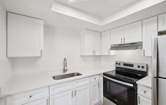 A white kitchen with a black oven and stove top.