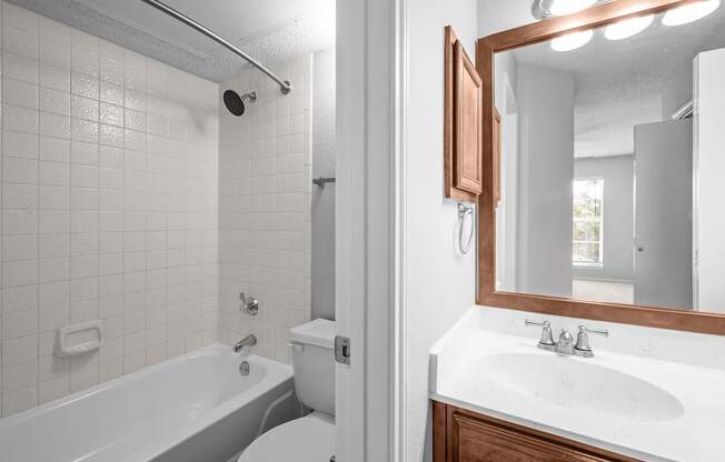 A white bathroom with a white toilet, white sink, and a white bathtub.