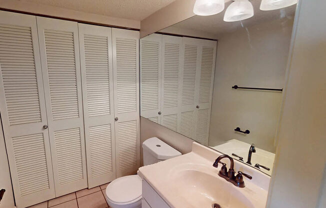 a bathroom with white cabinets and a sink and a toilet