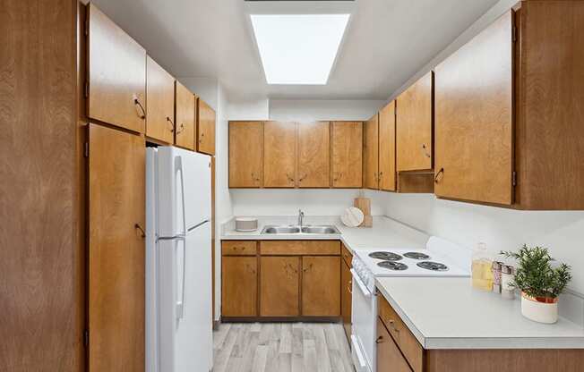 Model Kitchen with Dark Wood Cabinets and Wood-Style Flooring at Walnut Creek Apartments located in Walnut Creek, CA.