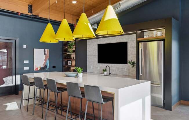 A modern kitchen with a white countertop and grey bar stools.