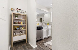 a kitchen with white cabinets and a shelf with spices