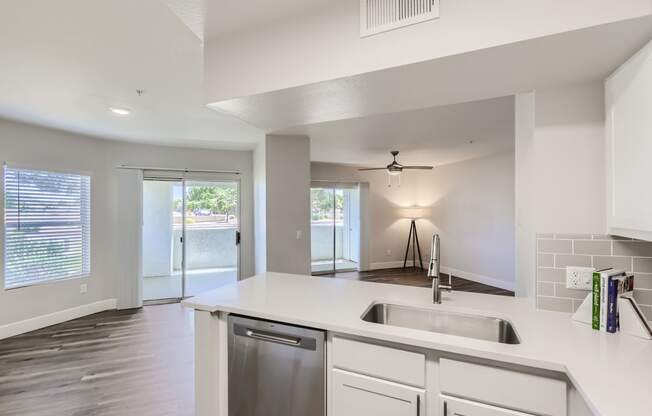 a kitchen with white cabinets and a stainless steel dishwasher