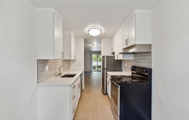 a kitchen with white cabinets and black appliances and a black stove