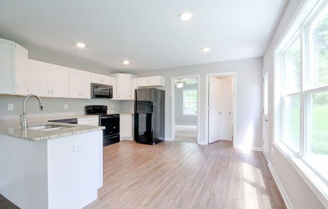 Two Story Duplex With Hardwood Flooring and White Cabinetry