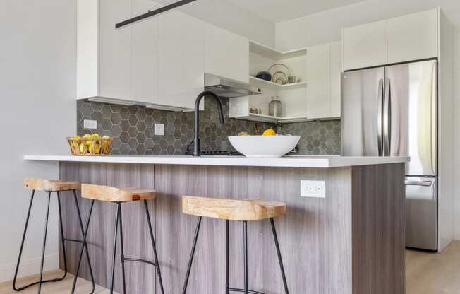 a kitchen with a counter top and three stools