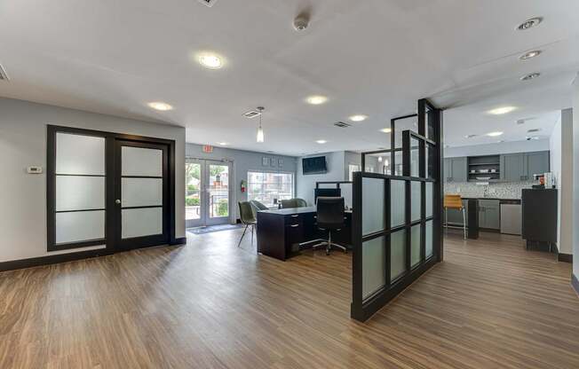 A modern office space with wood flooring and glass walls.