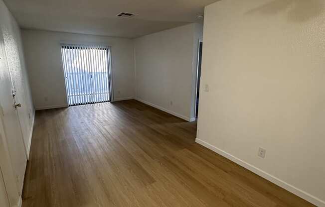 a view down a hallway with wood flooring and a window